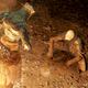 Two fantasy warriors regard each other beside a campfire, one bowing and the other squatting.